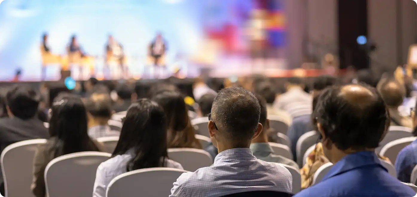 AV Rentals for Events – Live Conference Audience View Audience view at live event with AV rental setup including stage lighting and sound
